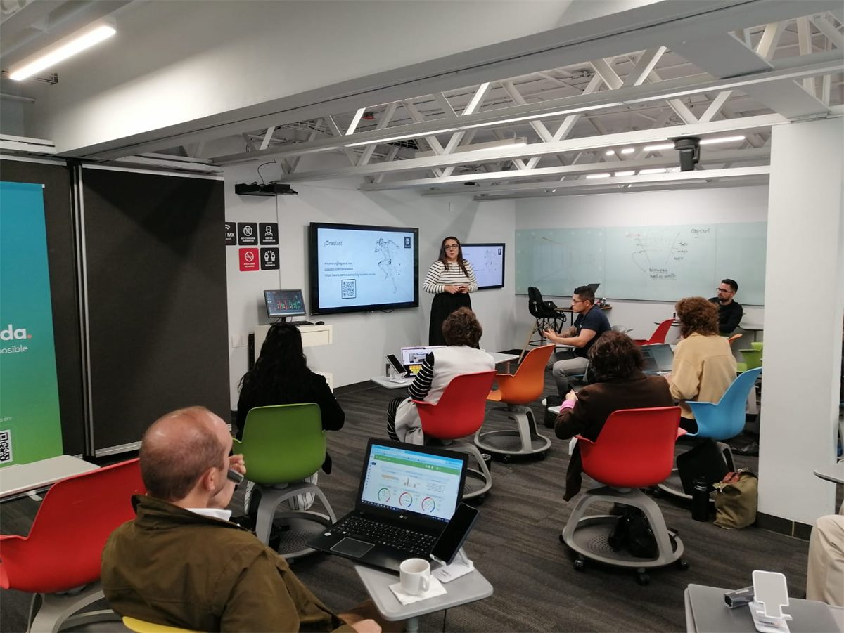 Alejandra Álvarez impartiendo un taller en un aula con asistentes con laptops